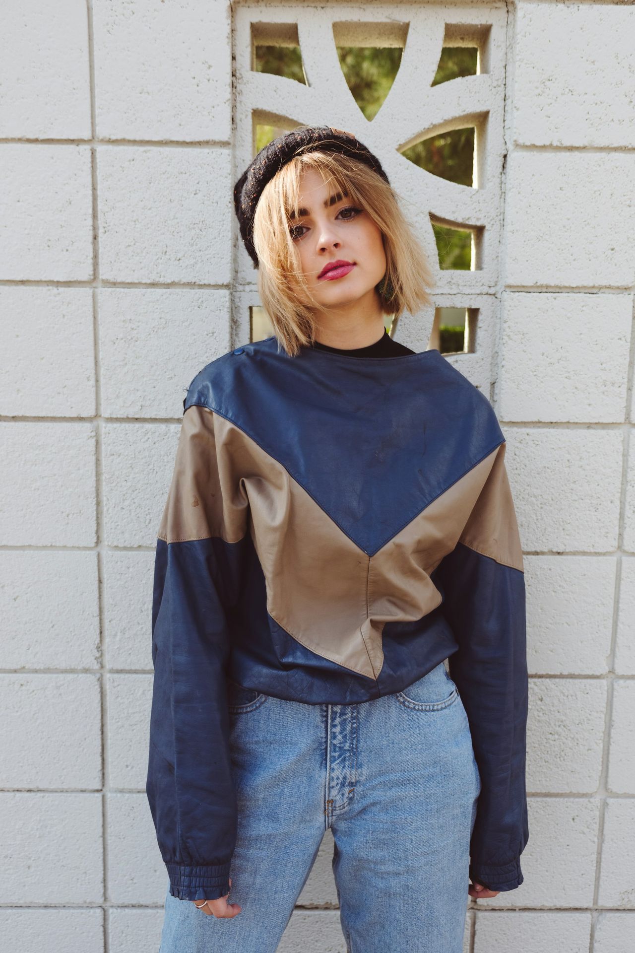 a woman standing in front of a white wall